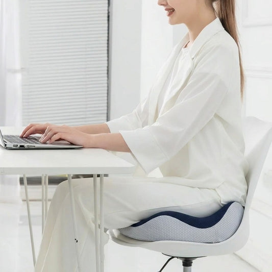 Femme en télétravail assise sur une chaise équipée du coussin ergonomique ErgoSeat