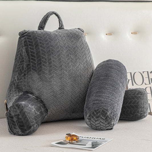 Coussin de lecture gris installé sur un lit