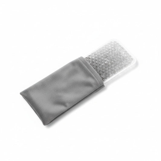Coussinet à perles de gel transparentes à moitié glissé dans sa housse grise, sur fond blanc