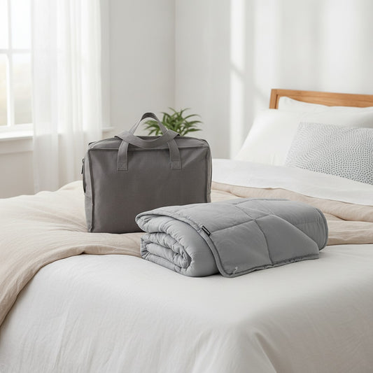 Couverture lestée Sweikett 7 kg gris avec son sac de transport sur un lit