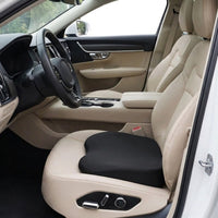 Coussin rehausseur noir posé sur le siège conducteur d’une voiture à intérieur beige