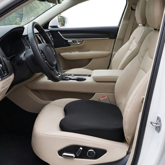 Coussin rehausseur noir posé sur le siège conducteur d’une voiture à intérieur beige