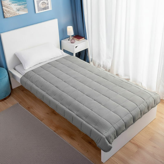Couverture lestée 120x180 cm grise déployée sur un lit individuel