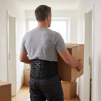 Mise en situation : homme portant un carton de déménagement, ceinture lombaire noire sur le t-shirt