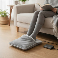 Mise en situation : pieds glissés dans le chauffe-pieds devant le canapé, branché sur une batterie externe