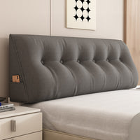Le coussin de relax gris foncé contre la tête de lit