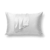 Taie d’oreiller en soie double face blanche sur un oreiller, sur fond blanc