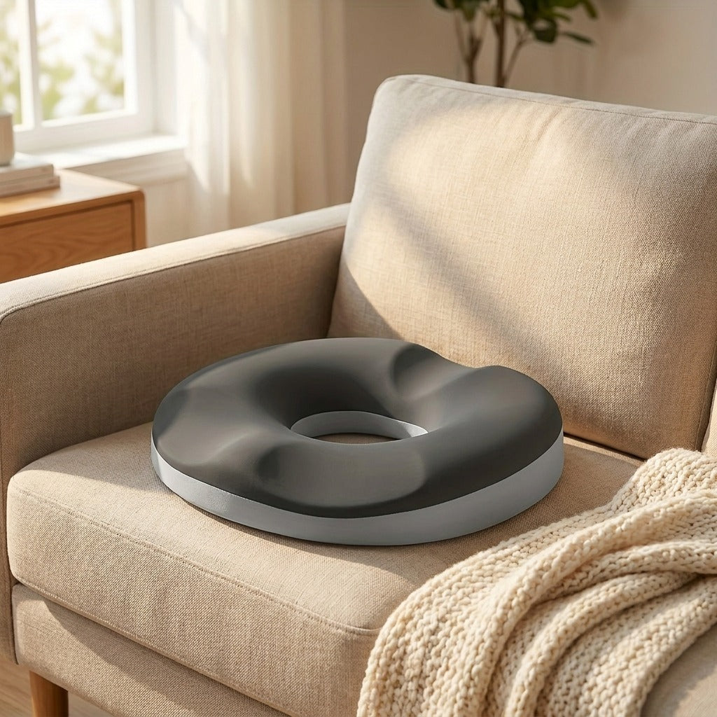 Le coussin bouée posé sur l'assise d'un canapé, à côté d'un plaid