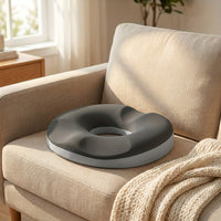Le coussin bouée posé sur l'assise d'un canapé, à côté d'un plaid