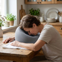 Mise en situation : assis à table, front posé sur le coussin, visage vers le bas