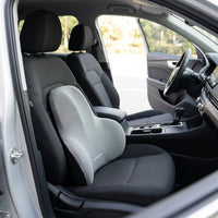 Coussin lombaire gris posé contre le dossier du siège conducteur d'une voiture