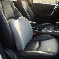 Coussin gris utilisé comme appui pour le bas du dos contre le dossier d’un siège de voiture