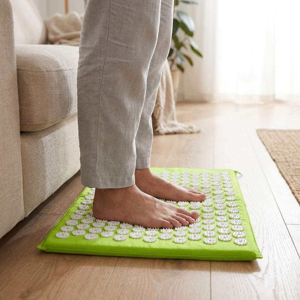 Pieds nus posés debout sur le tapis d'acupression, près d'un canapé