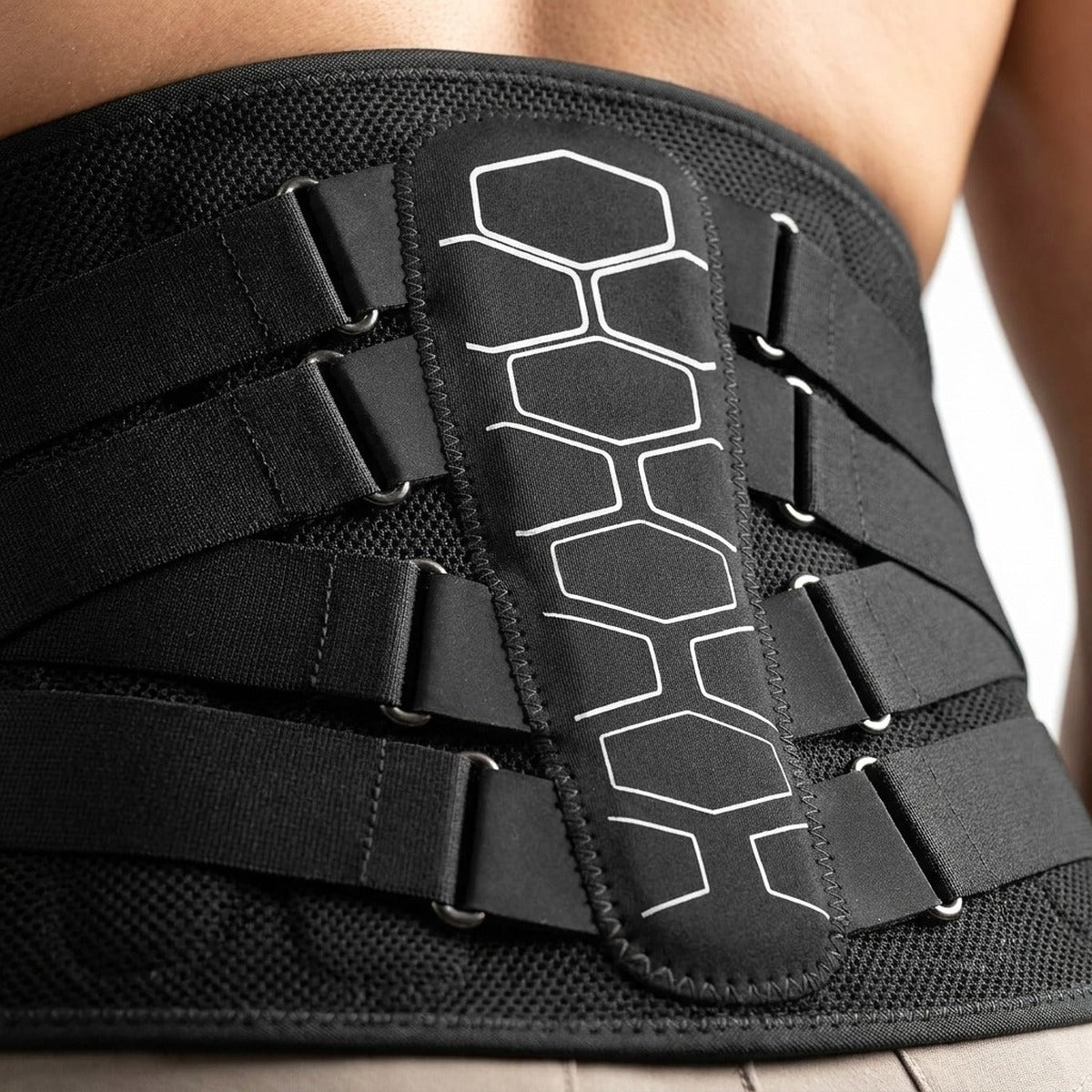 Détail : panneau dorsal à motif hexagonal, sangles de serrage dans leurs anneaux métalliques et maille 3D