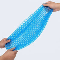 Coussin en gel nid d’abeille étiré entre deux mains, montrant son élasticité