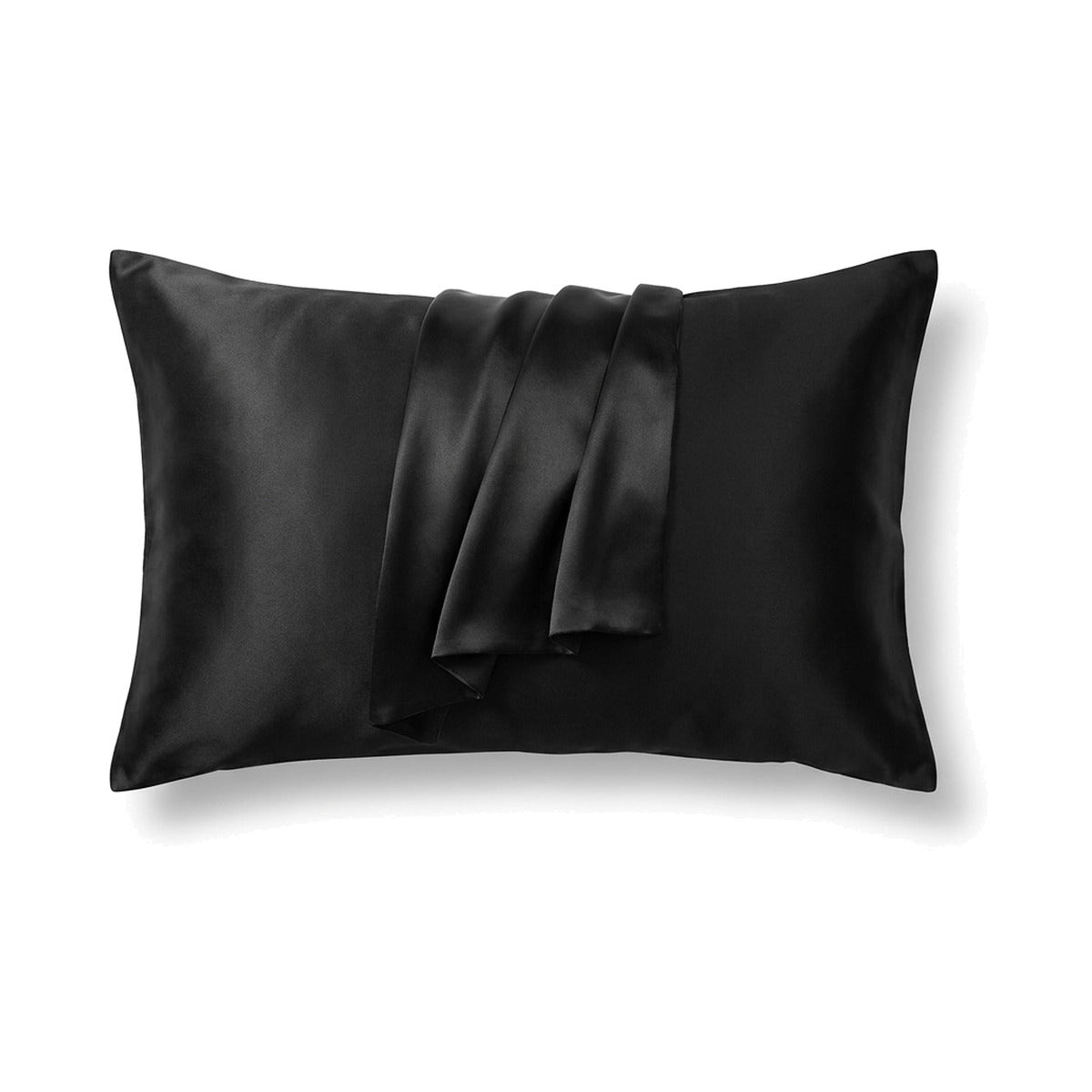 Taie d’oreiller en soie double face noire sur un oreiller, sur fond blanc
