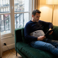Mise en situation : lecture sur le canapé, la ceinture chauffante autour de la taille
