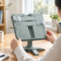 Support de lecture vert sauge posé sur un bureau en bois