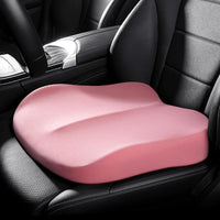 Coussin carré rose installé sur un siège de voiture