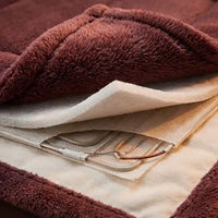 Couverture chauffante Beurer HD75 grise installée sur un lit