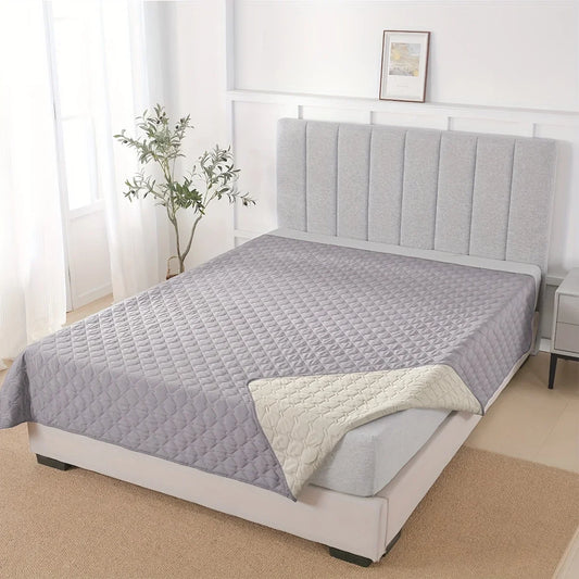 Le protecteur de mobilier Le Gardien™ gris déployé sur un lit, illustrant sa grande taille et sa capacité à protéger la literie de l'humidité et des poils.
