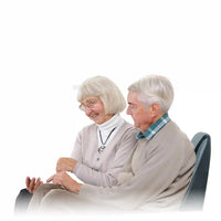 Couple senior utilisant un coussin massant pour le dos avec télécommande intuitive
