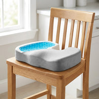 Coussin d’assise gris avec insert en gel sur une chaise de cuisine en bois, ouverture tournée vers le dossier — mise en situation illustrative
