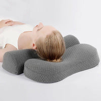 Vue de profil d'une personne allongée entre un grand coussin gris et une pièce demi-ronde séparée
