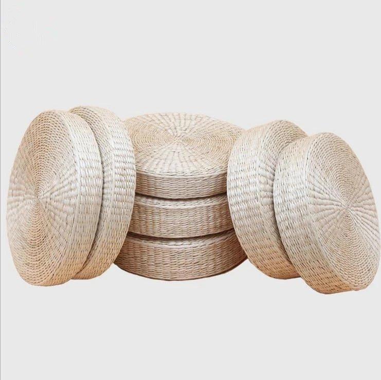 Plusieurs coussins de sol ronds à surface tressée présentés empilés