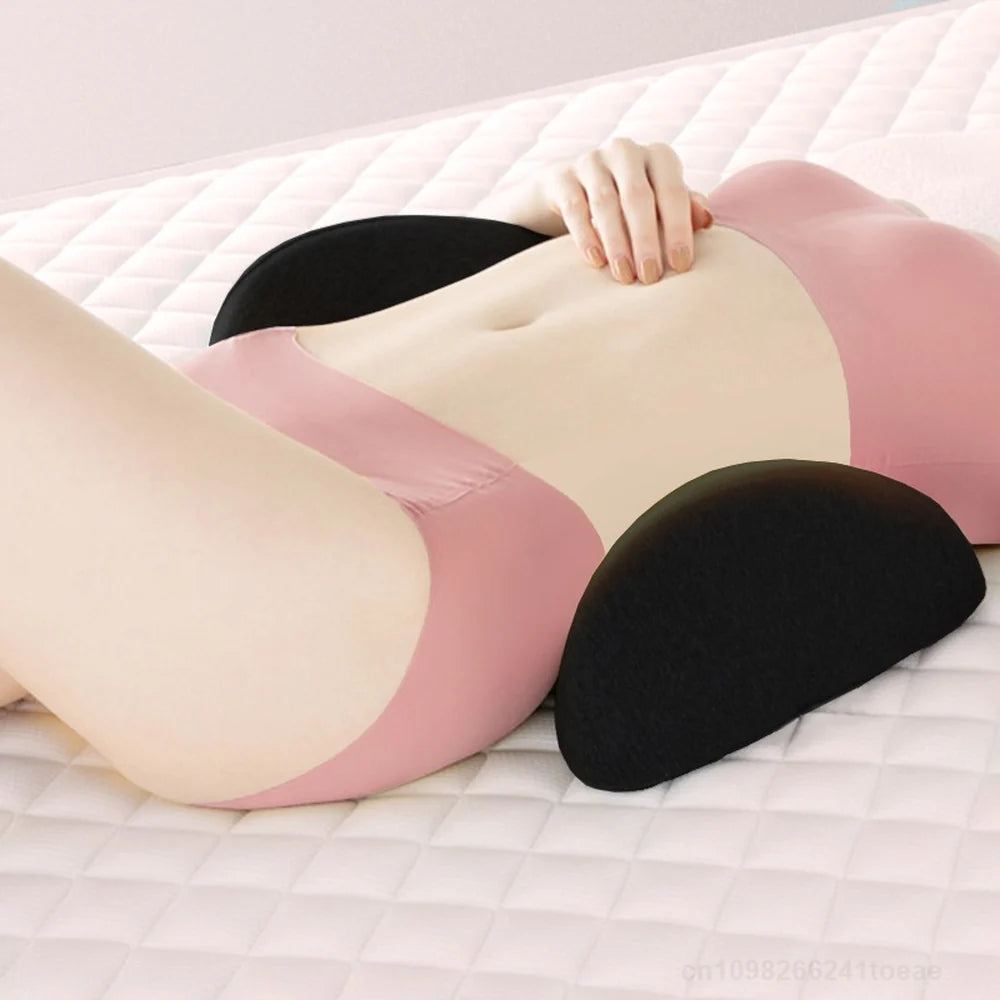 Coussin lombaire noir glissé sous le creux du dos d’une personne allongée sur un lit