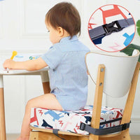 Coussin rehausseur carré multicolore placé sur une chaise devant une table