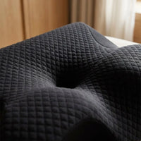 Gros plan du tissu matelassé noir et du creux central de l’oreiller DreamContour