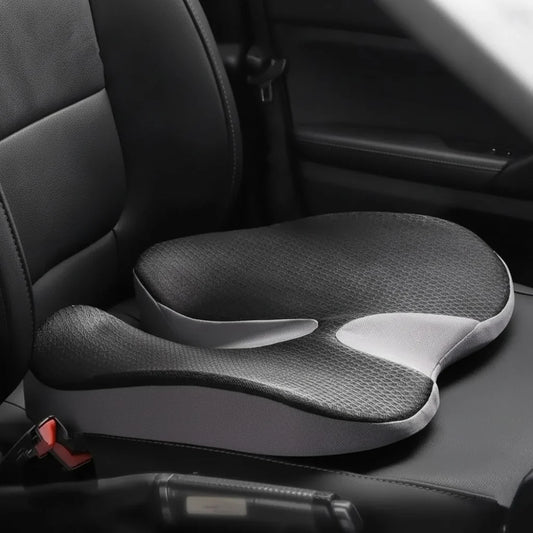 Coussin incliné ErgoDrive noir et gris clair posé sur un siège conducteur en cuir noir