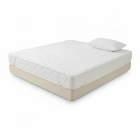 Protège-matelas blanc matelassé installé sur un lit