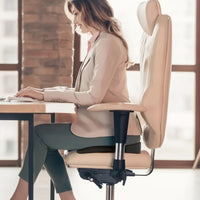 Utilisatrice assise au bureau sur le coussin PostureCore noir posé sur sa chaise