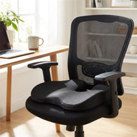 Coussin SciatiGuard noir à découpe en U posé sur une chaise de bureau