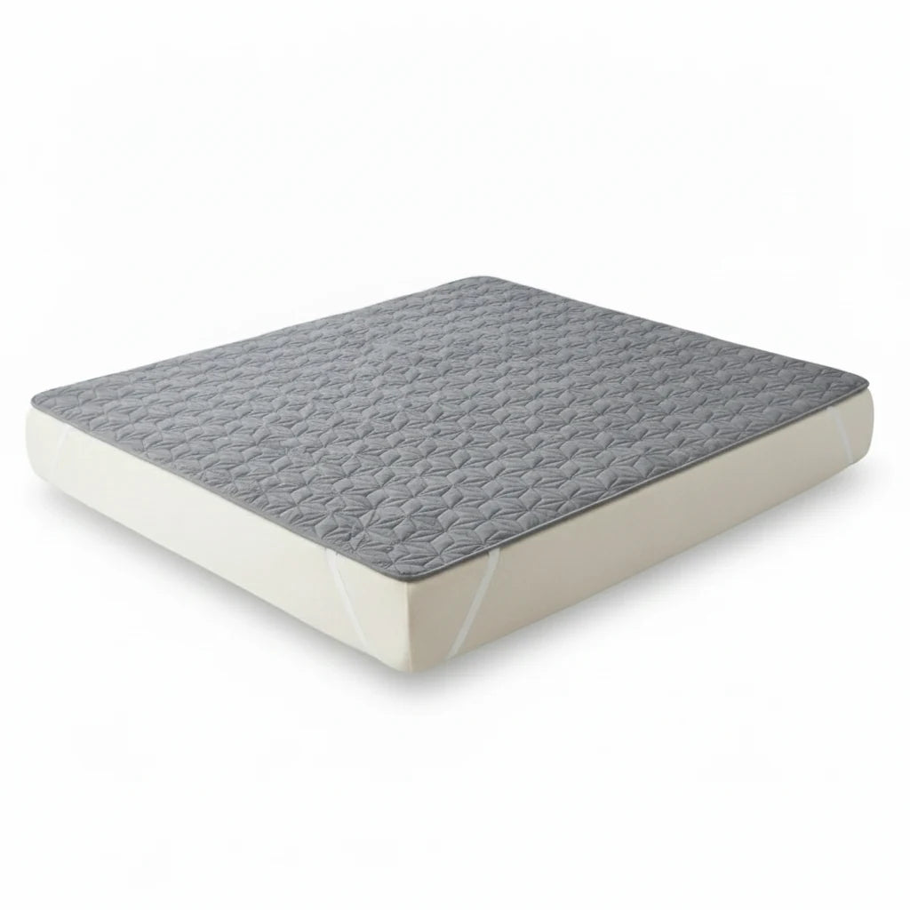 Protège-matelas gris matelassé présenté sur un matelas