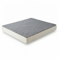 Protège-matelas gris matelassé présenté sur un matelas